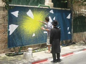 עמרי פישר מצייר על לוח הקיר ברחוב הע"ח במוסררה (הלוע"ח)